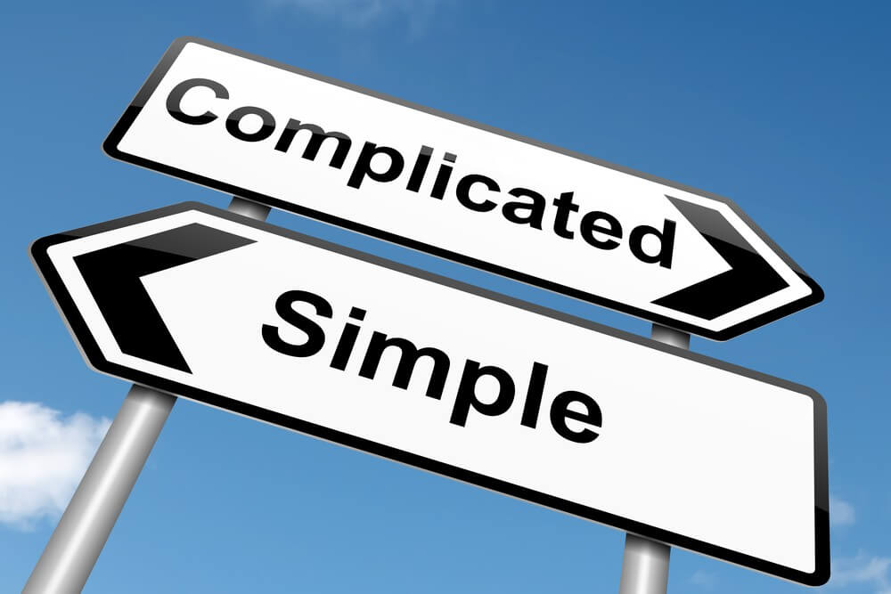 Two road signs pointing in opposite directions, one toward Simple, one toward Complicated